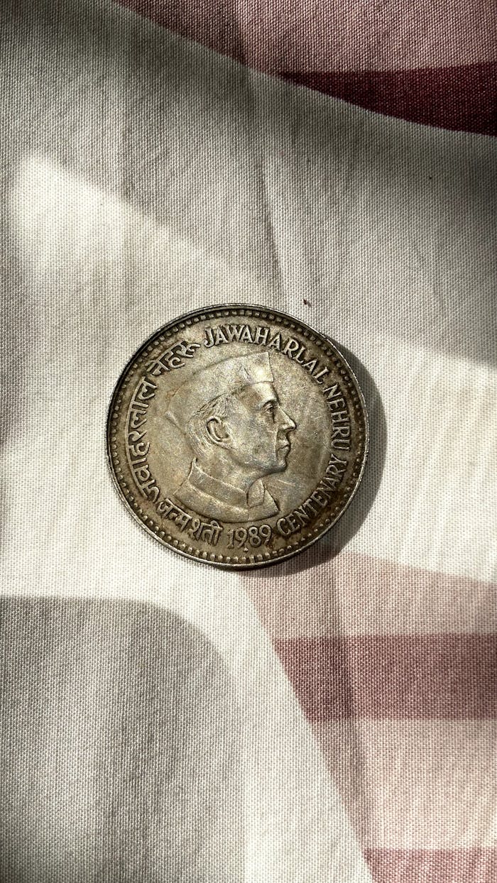 1959 Jawaharlal Nehru commemorative coin on fabric with vintage look.